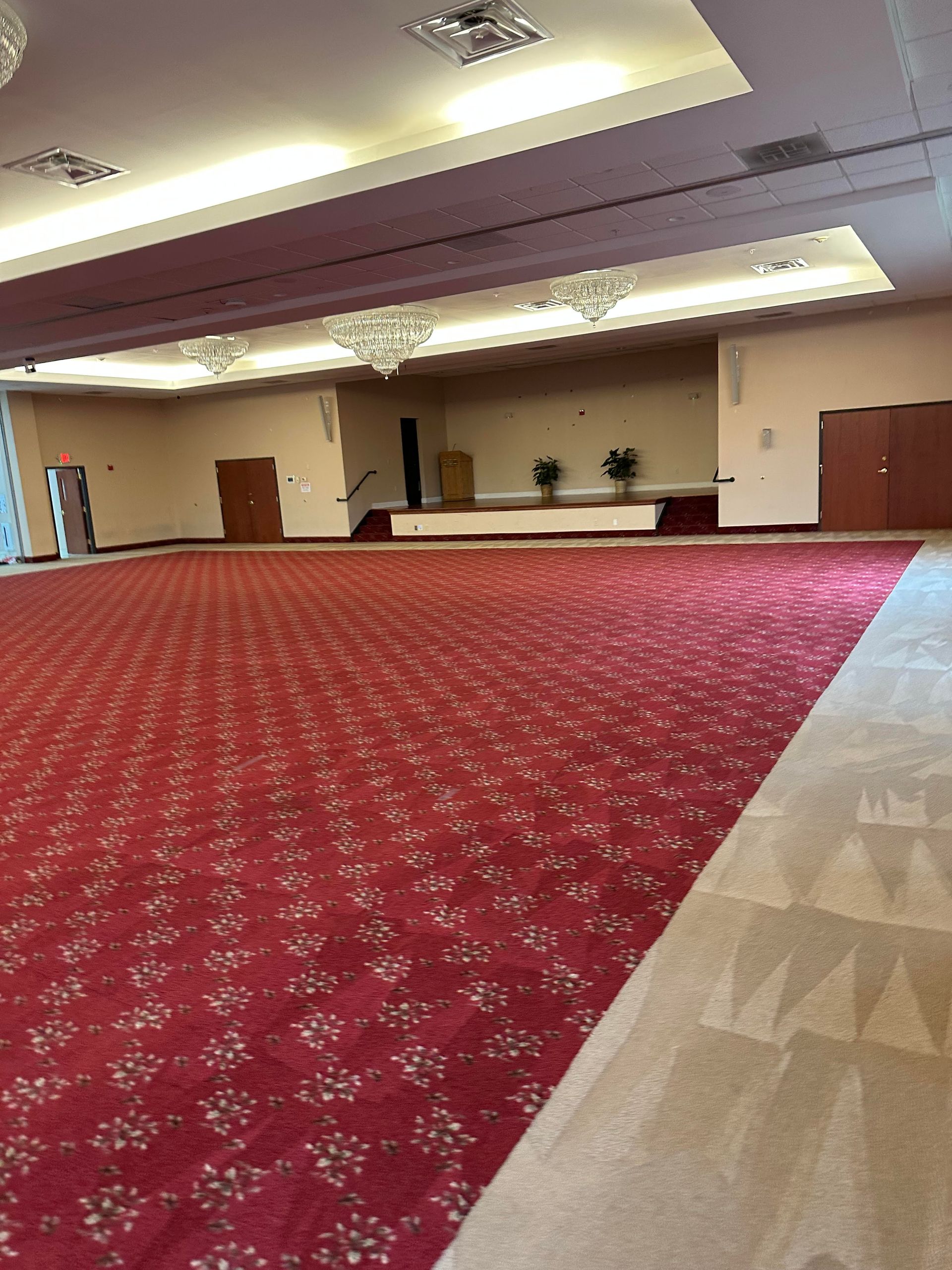 A large empty room with a red carpet on the floor.