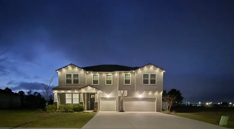 Two-story home with exterior lighting at dusk