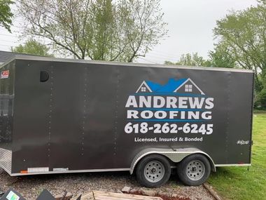 A dark gray enclosed trailer with white branding reading 