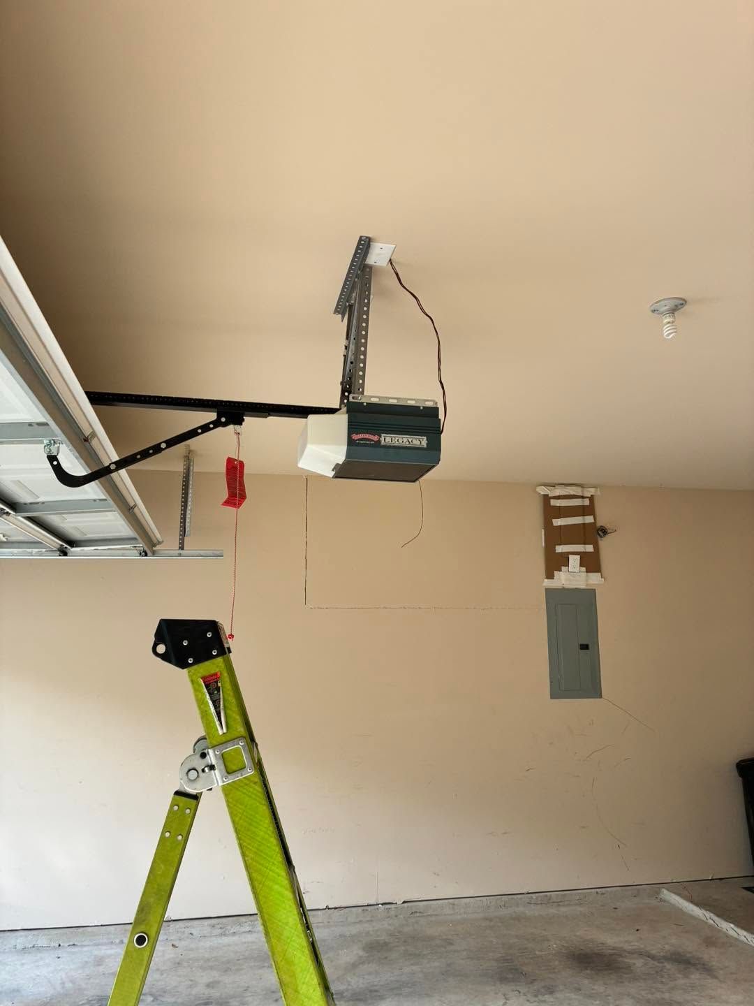 Garage ceiling with a ladder below and a garage door opener mounted overhead