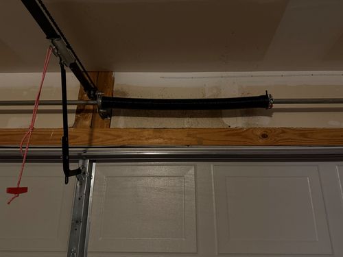 Garage door opener rail mounted above a white sectional garage door