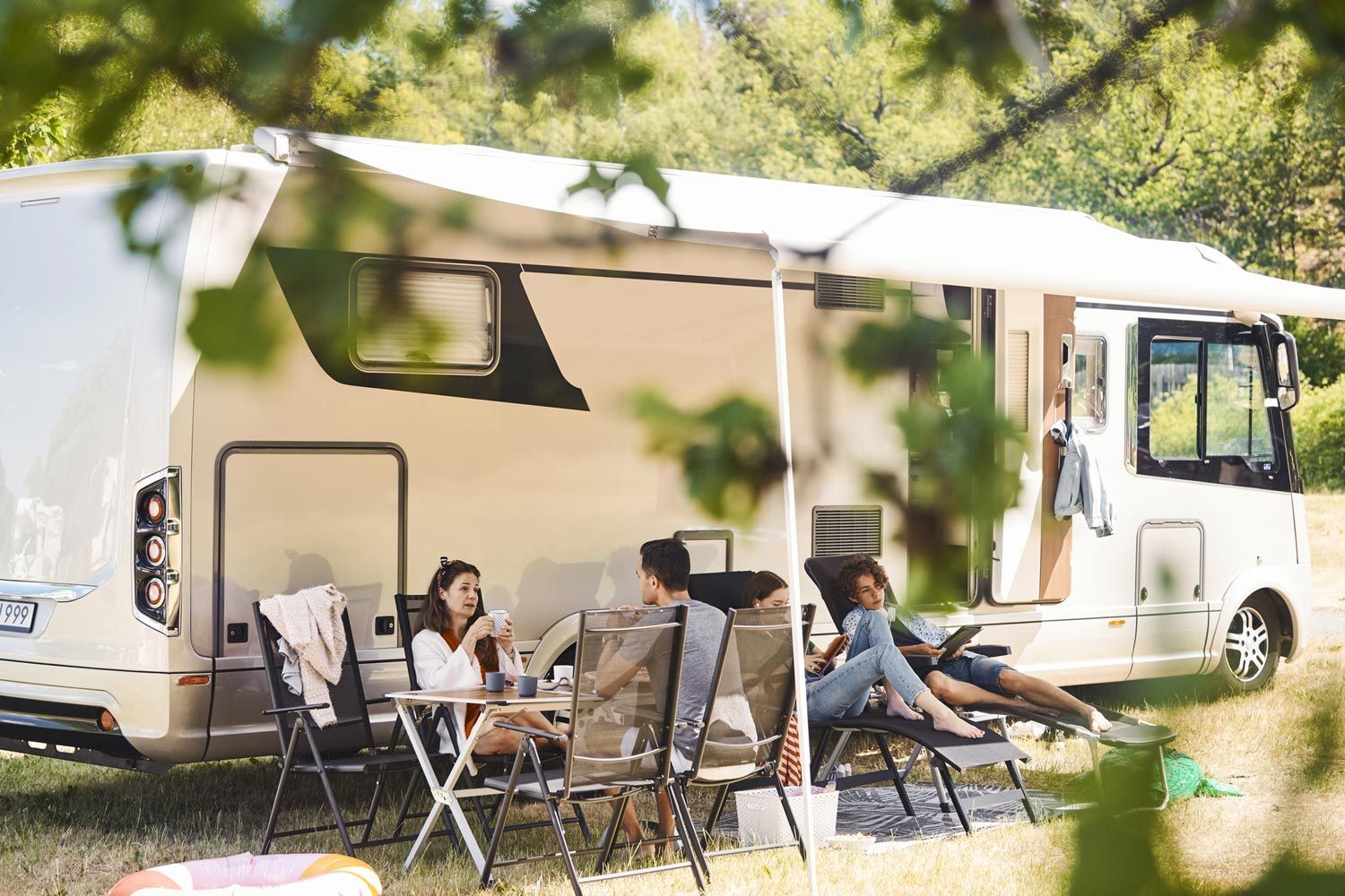 A Group of People are Sitting Outside of the RV A Group of People are Sitting Outside of the RV