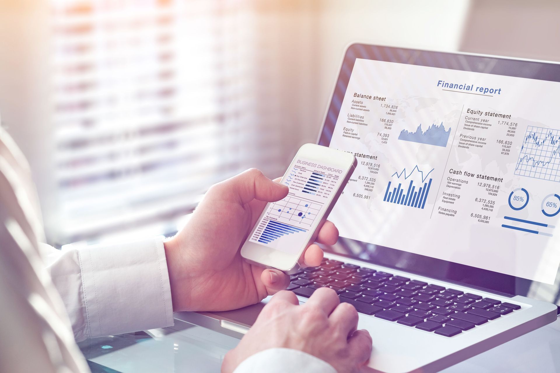 A Person Using a Laptop and Smartphone — Tenth Avenue Accountants & Financial Advisors in Newcastle, NSW