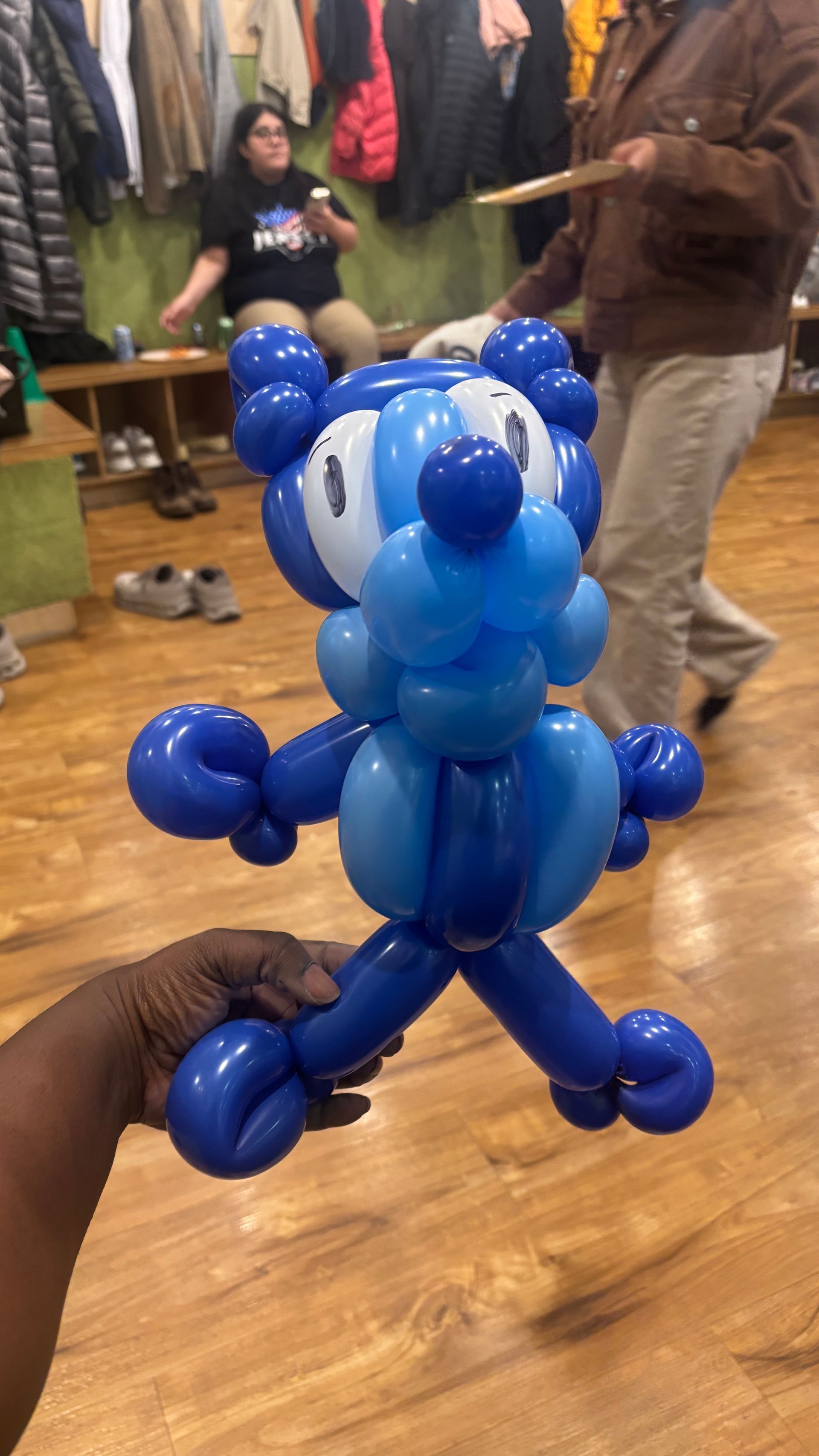 Blue balloon animal resembling a cartoon character, held up by a person.