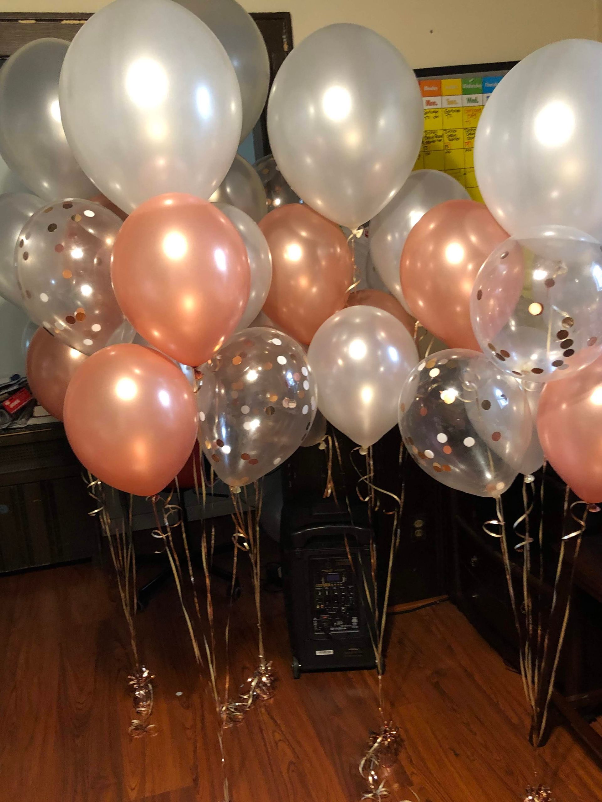 Balloons in metallic silver, rose gold, and clear with confetti; tied with gold string.