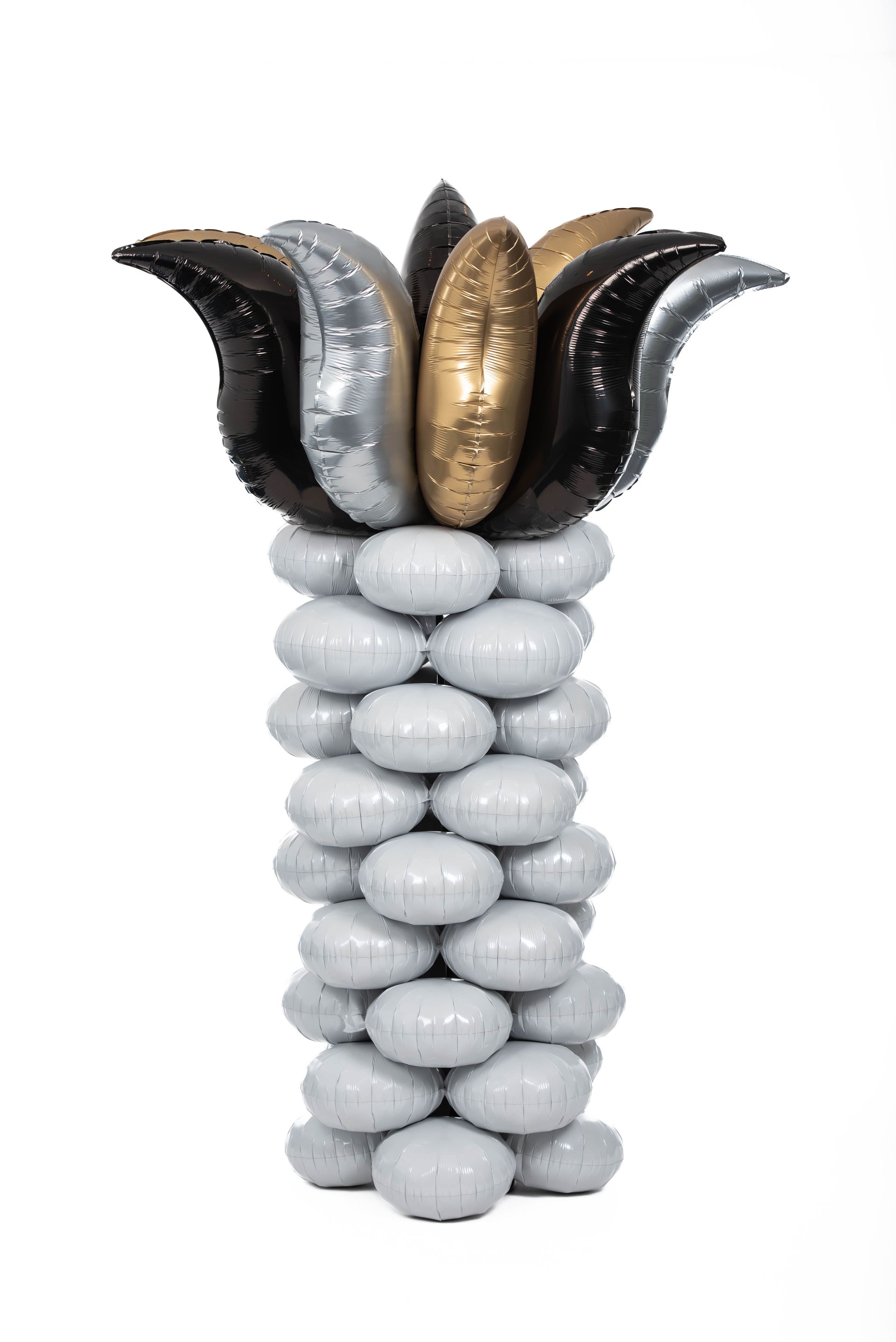 Balloon sculpture of a column with a flower-like top in silver, black, and gold colors.