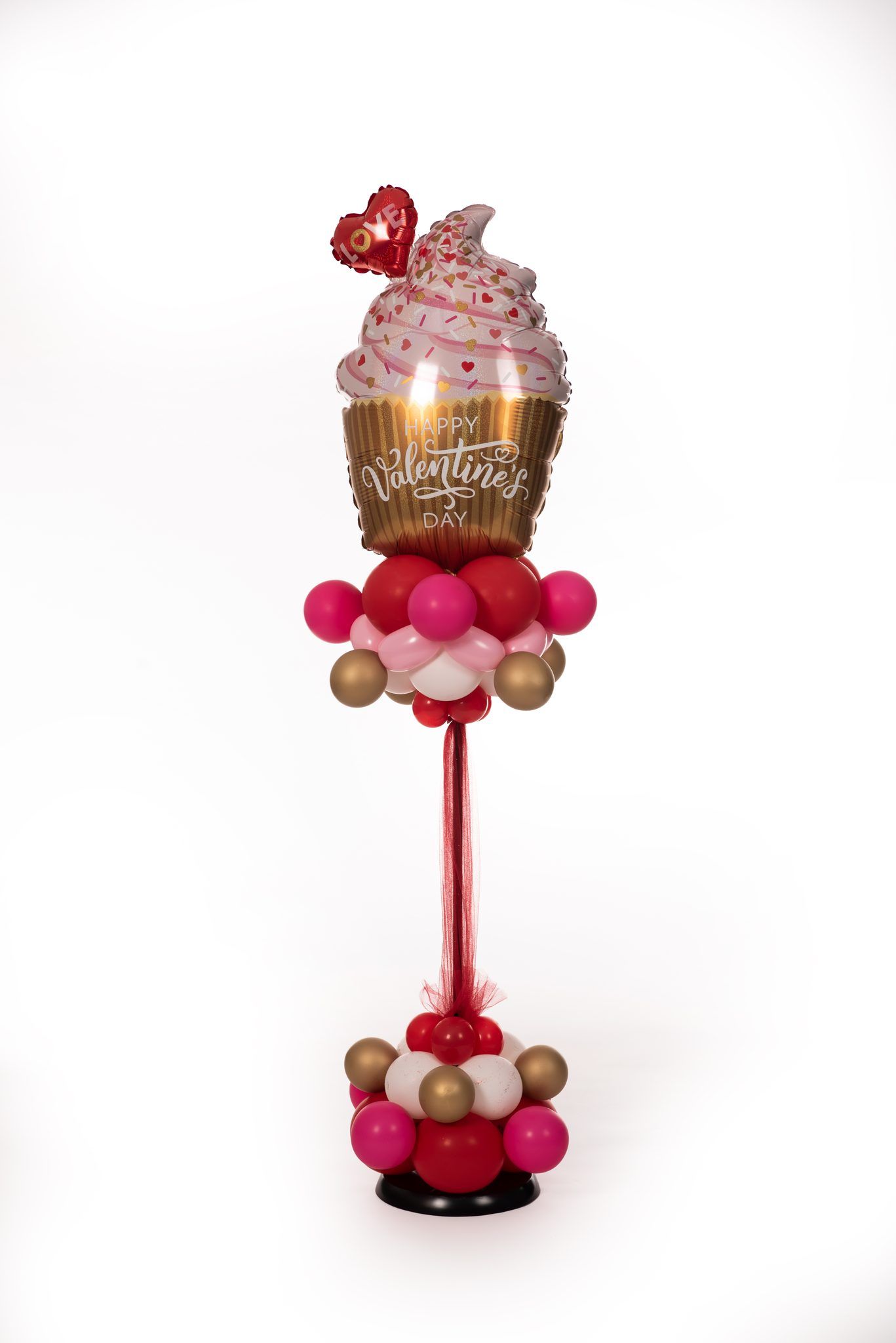Balloon art cupcake with red, pink, and gold balloons on a white background.