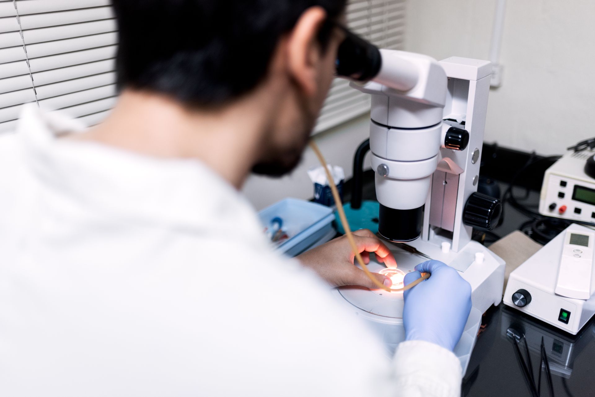 A man is looking through a microscope in a laboratory.
