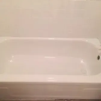 White bathtub in a bathroom against a light-colored wall.