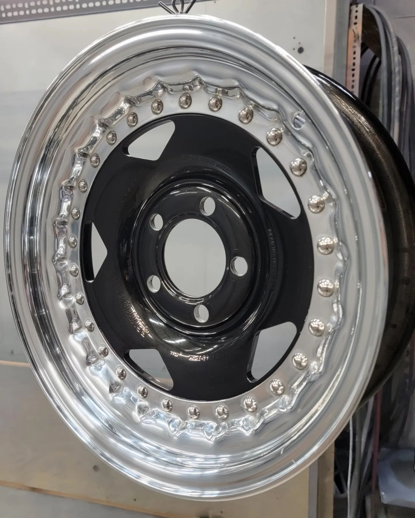 Black and silver car wheel rim with a polished outer ring and a black center section.