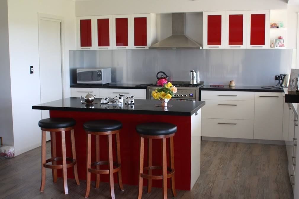 A Kitchen With Red Cabinets and Black Counter Tops — Crispin Cabinetmakers in Iluka, NSW