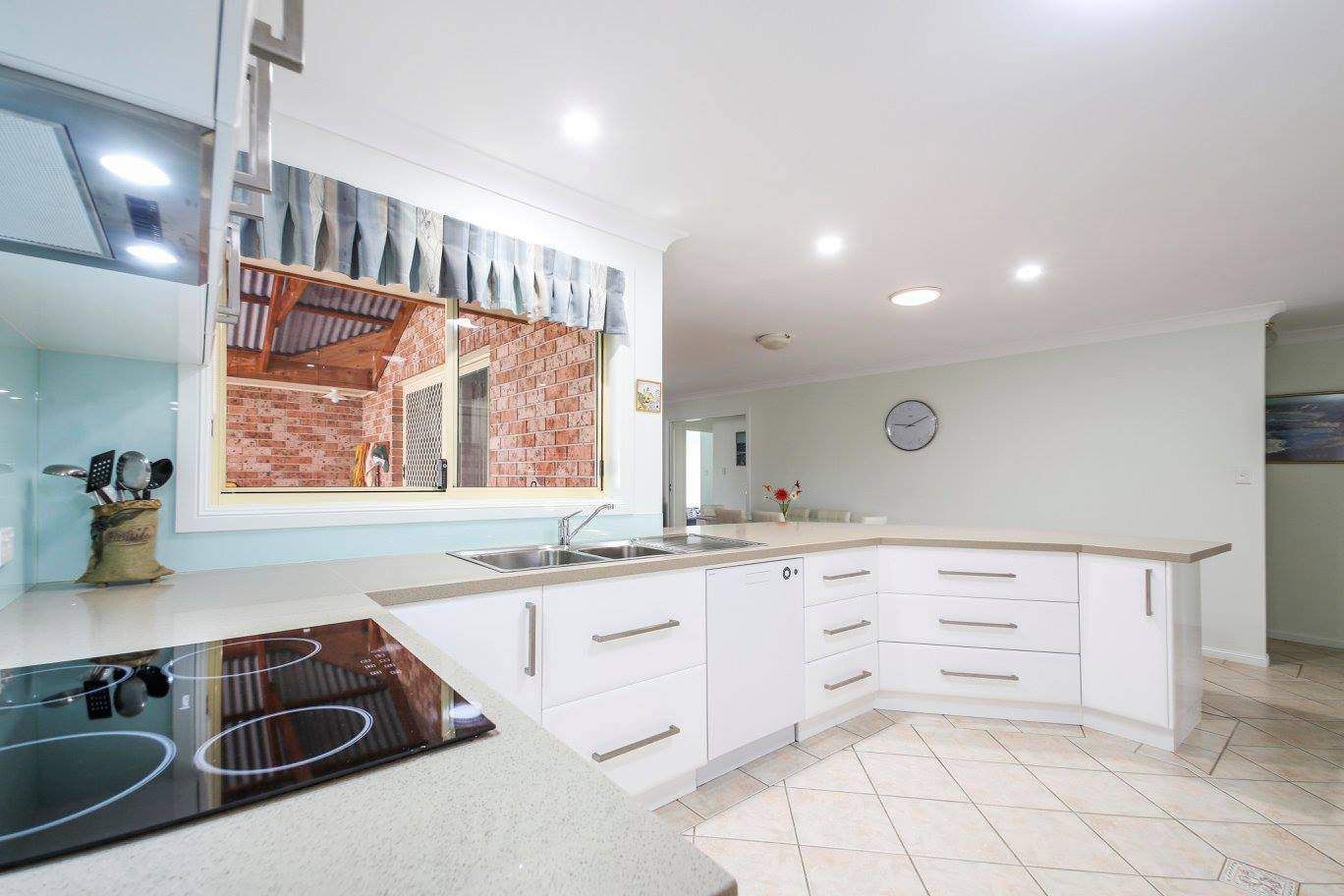 A Kitchen With White Cabinets and a Stove Top Oven — Crispin Cabinetmakers in Yamba, NSW