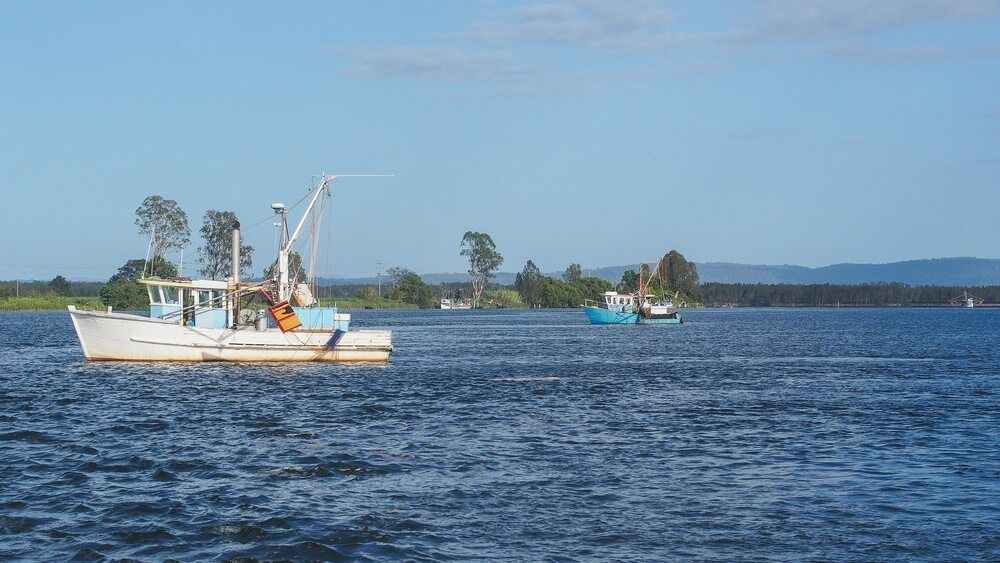 A Boat is Floating on Top of a Large Body of Water — Crispin Cabinetmakers in Maclean, NSW