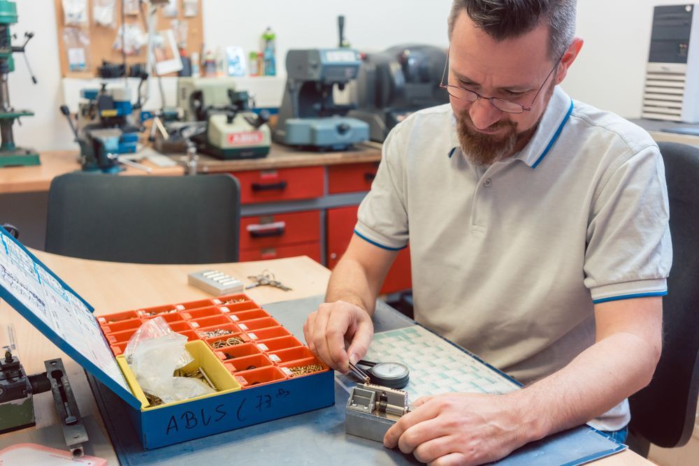 A Man is Working on a Key Cutting Machine in a Workshop — Darwin Lock & Key In Casuarina, NT