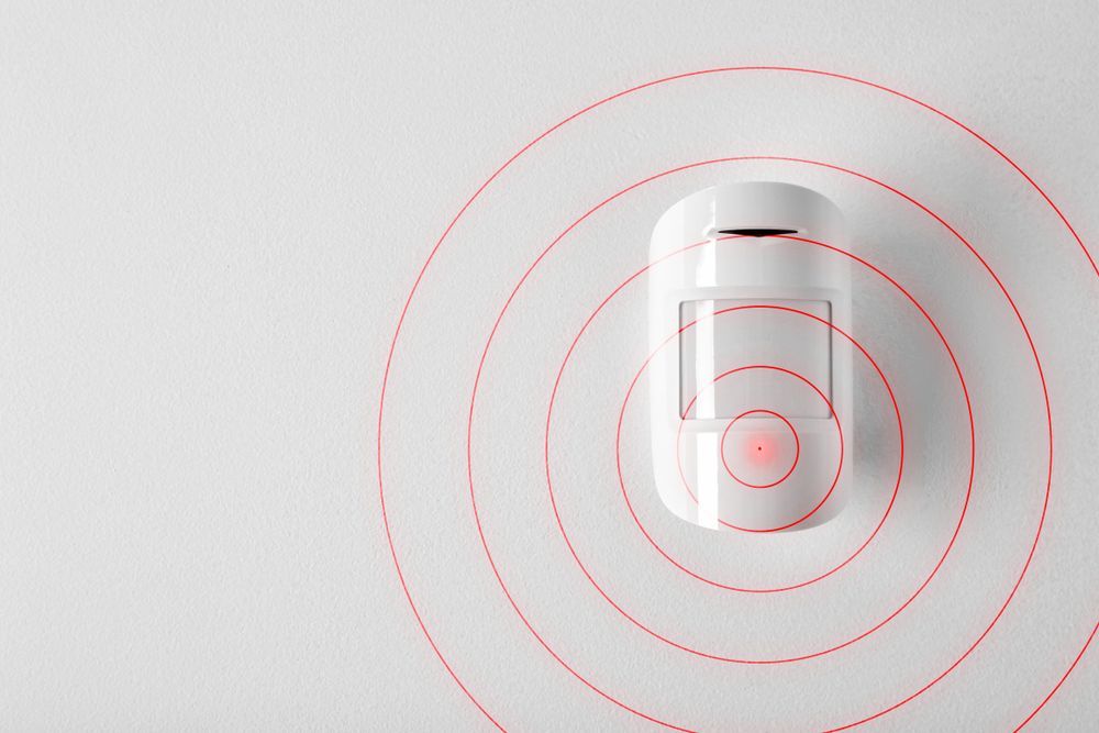 A White Motion Sensor is Surrounded by Red Circles on a White Surface — Darwin Lock & Key In Coconut Grove, NT