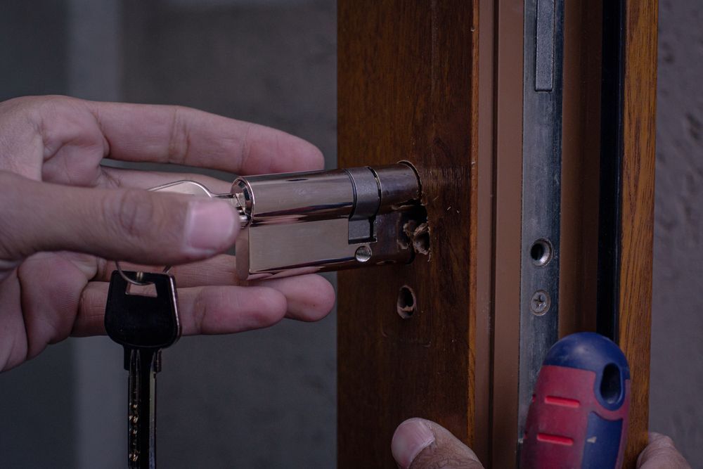 A Person is Fixing a Door Lock With a Screwdriver and a Key — Darwin Lock & Key In Howard Springs, NT