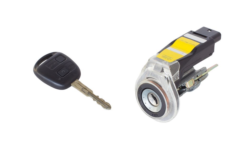 A Car Key Next to a Car Lock on a White Background — Darwin Lock & Key In Howard Springs, NT