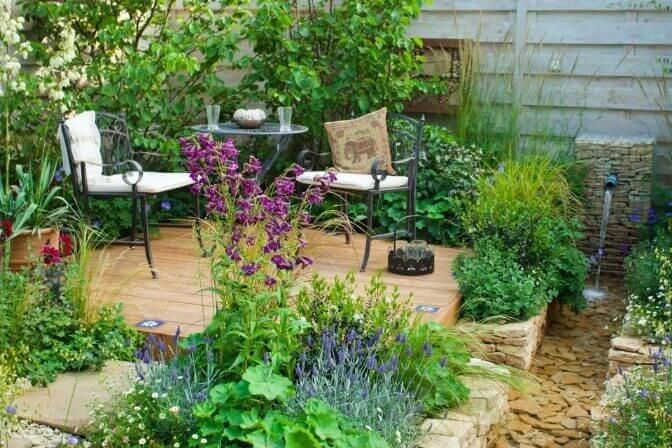 There is a table and chairs in the middle of the garden.