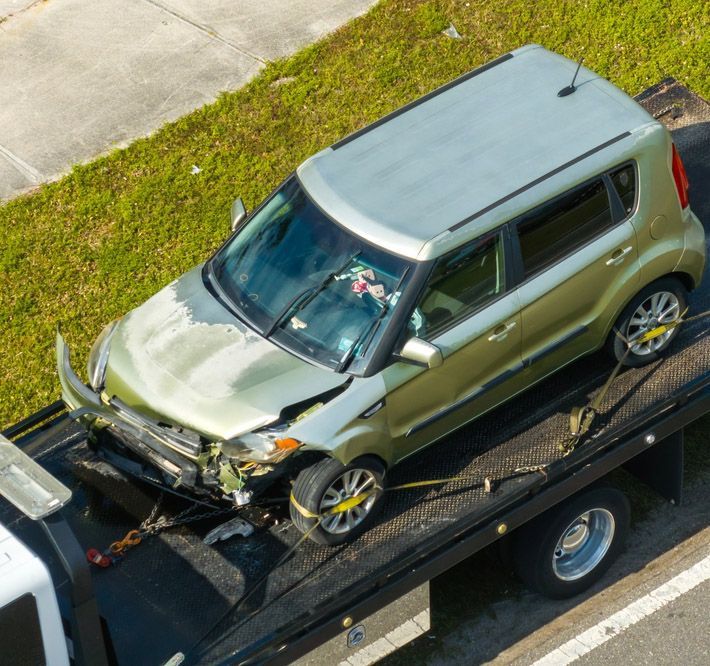 A Green SUV being Towed on a Flatbed Tow Truck — Westside Panels & Towing in Prospect Vale, TAS