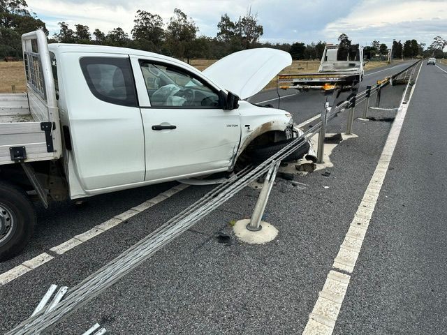 White pickup truck crashed into highway barrier with hood open on a road shoulder.— Westside Panels & Towing in Prospect Vale, TAS