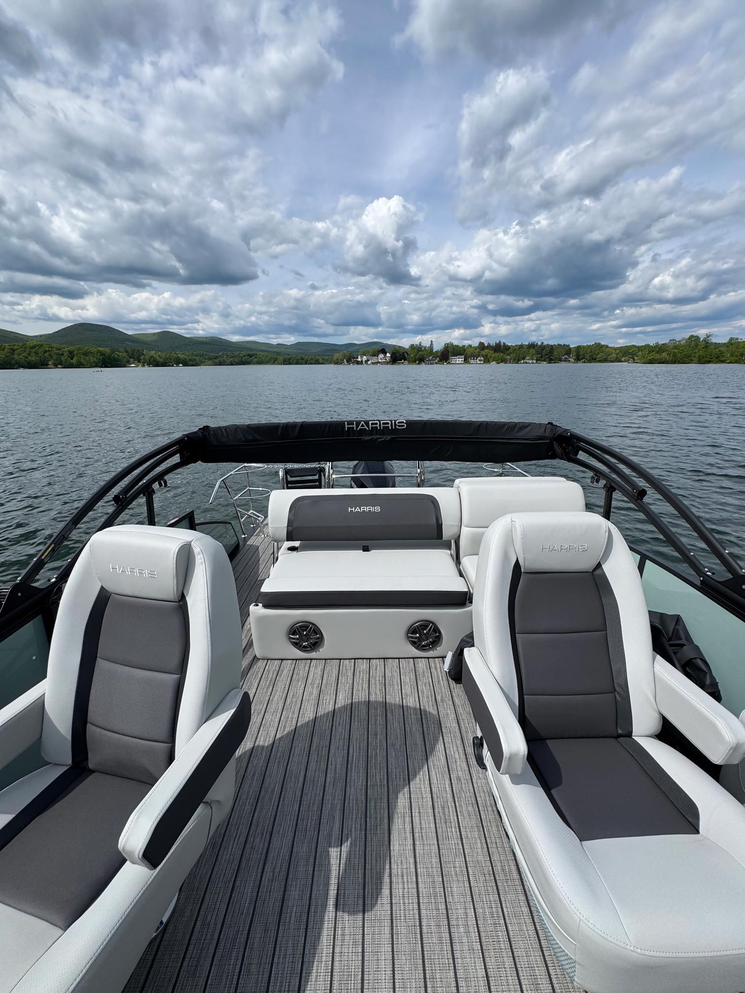 A boat is floating on top of a lake on a cloudy day.