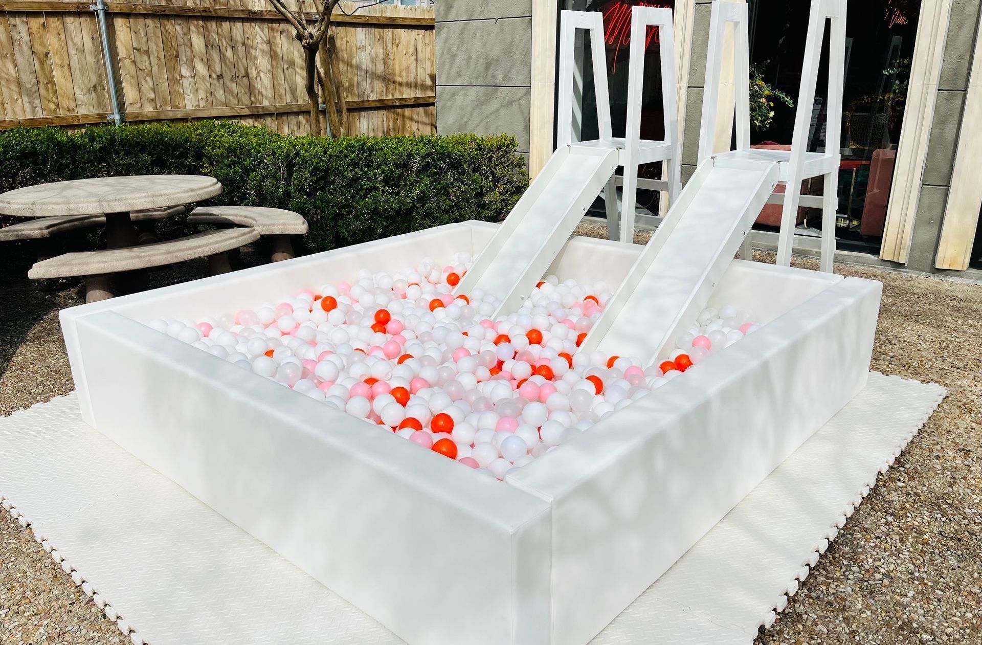 A large ice pool with a slide and chairs in it.