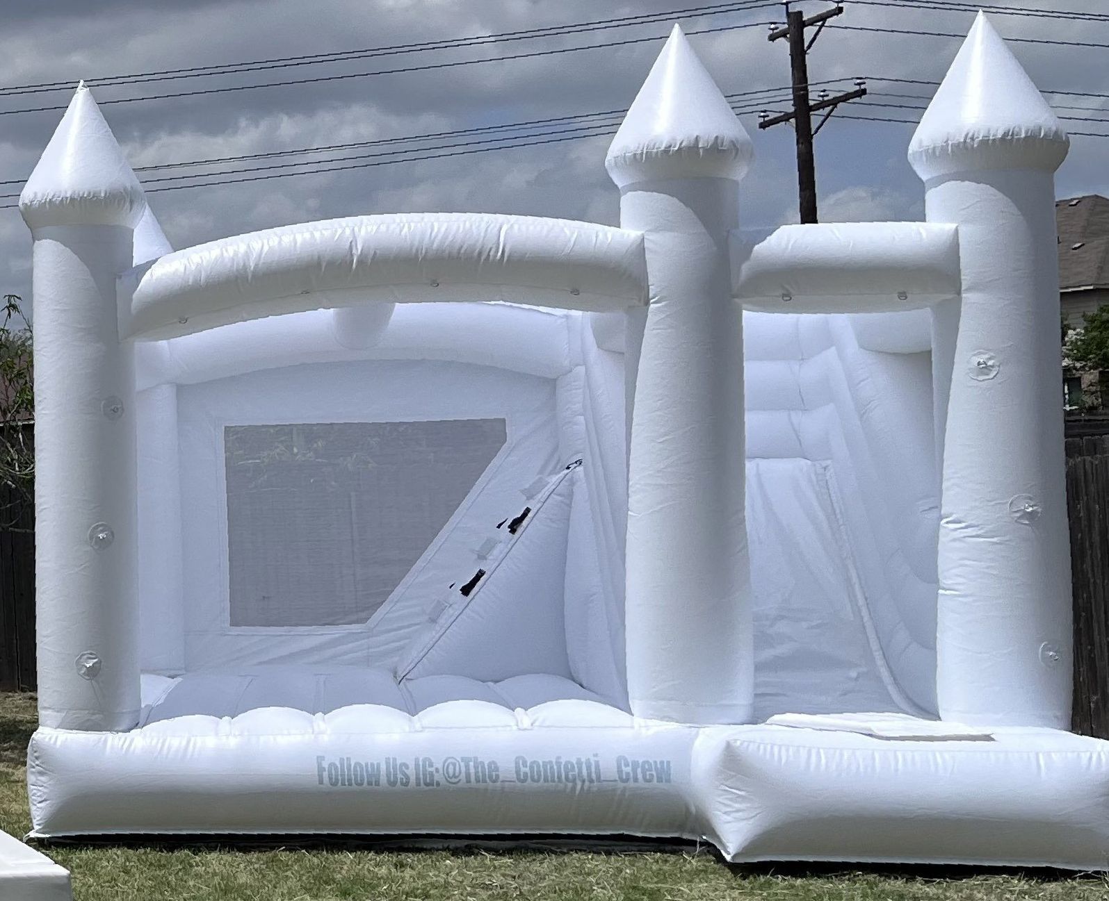 A white bouncy castle is sitting in the grass