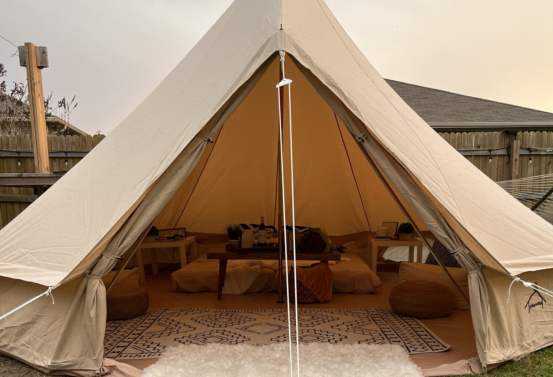A tent with a table and pillows inside of it.
