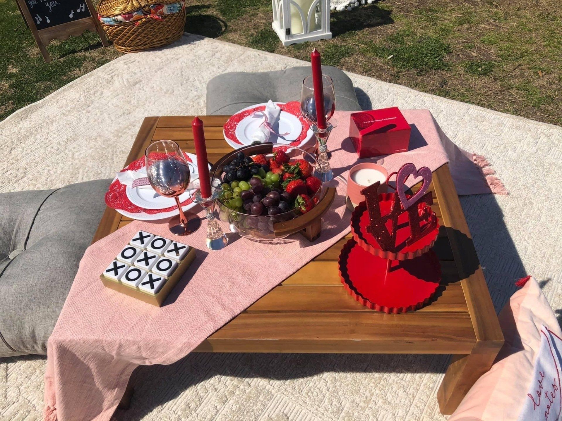 A wooden table with plates , candles , and fruit on it.