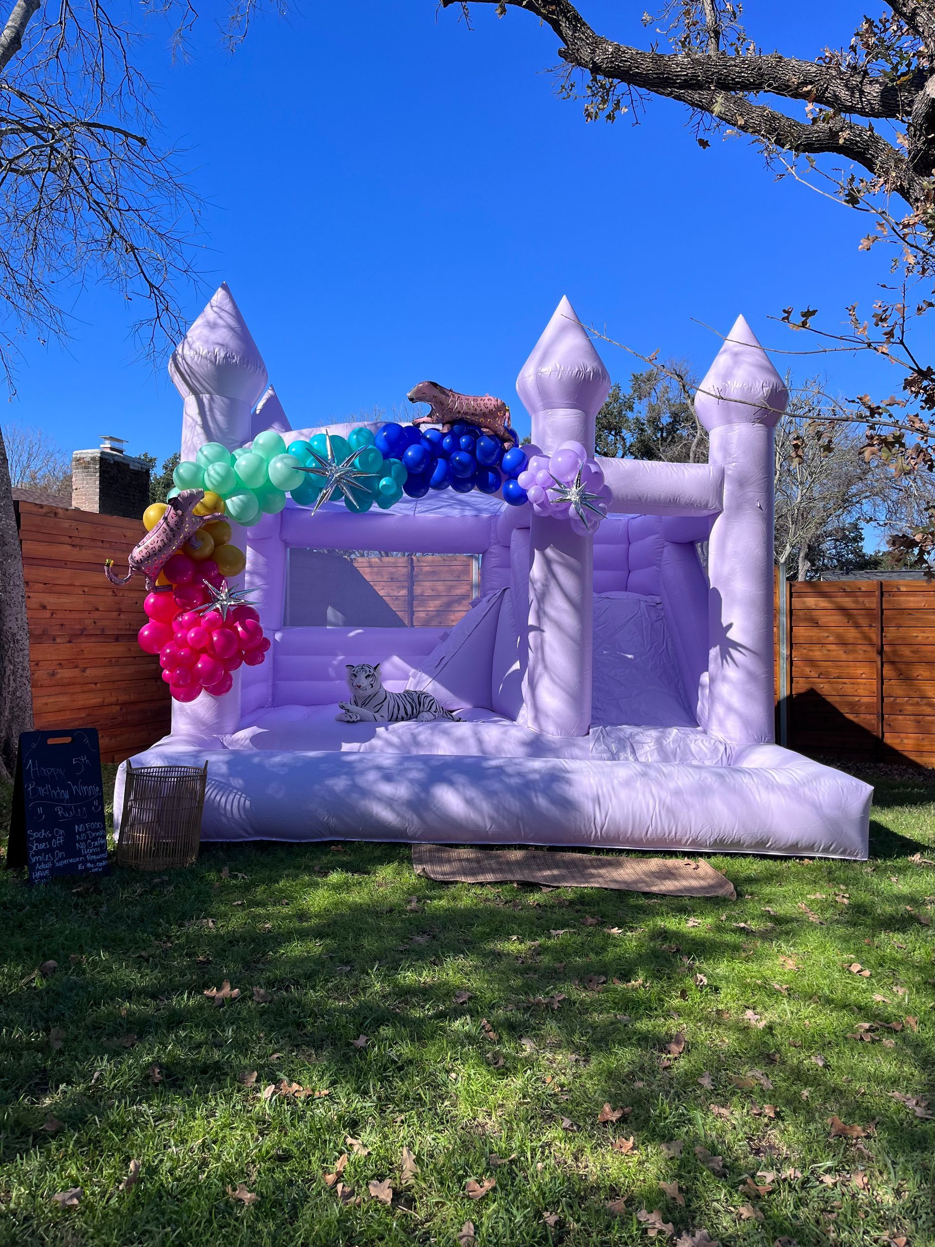 A purple bouncy castle is sitting on top of a lush green field.
