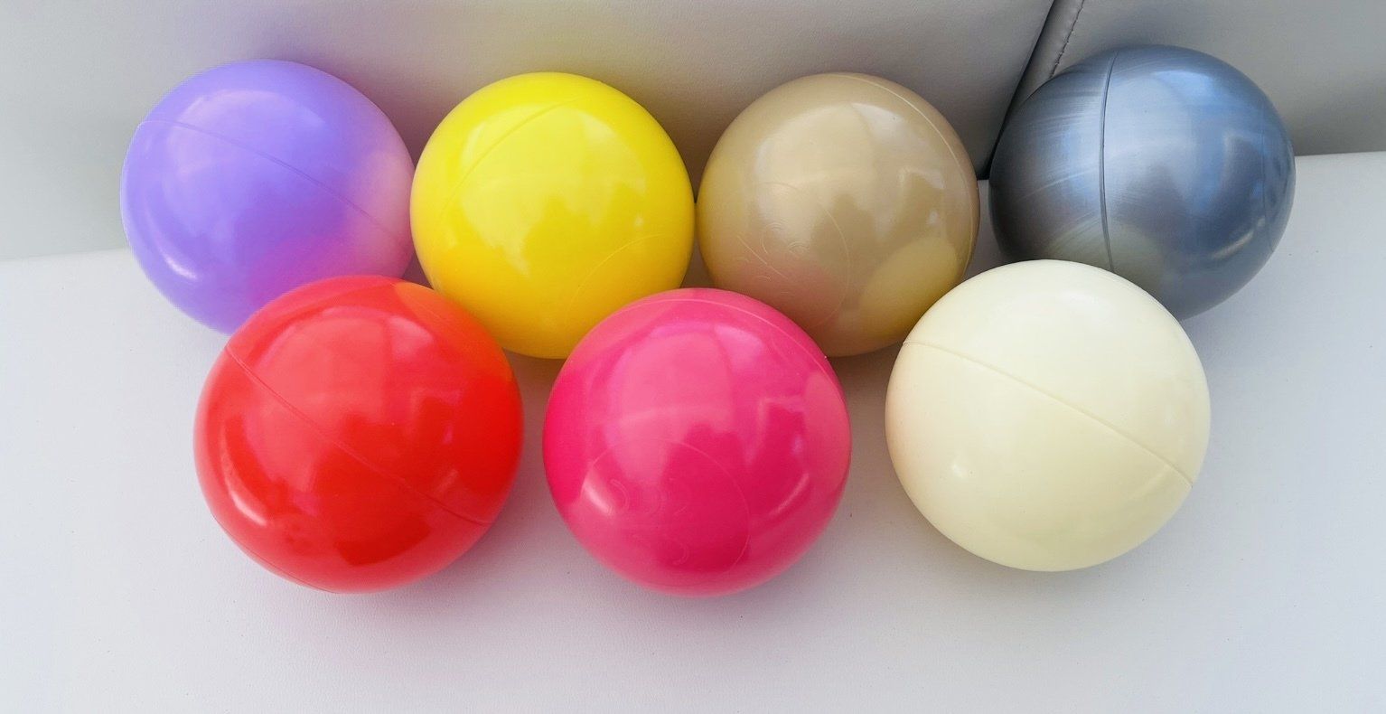 A bunch of different colored balls are sitting on a table