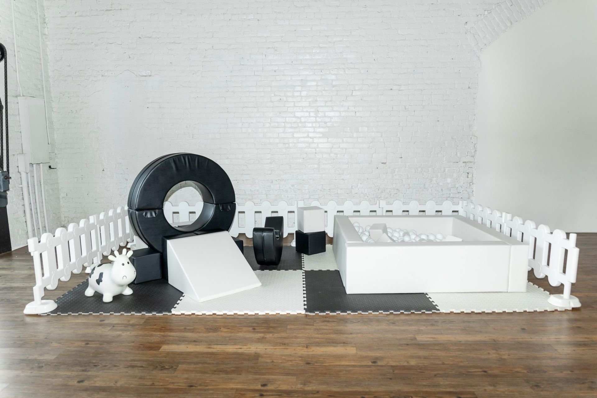 A black and white play area with a white fence surrounding it.