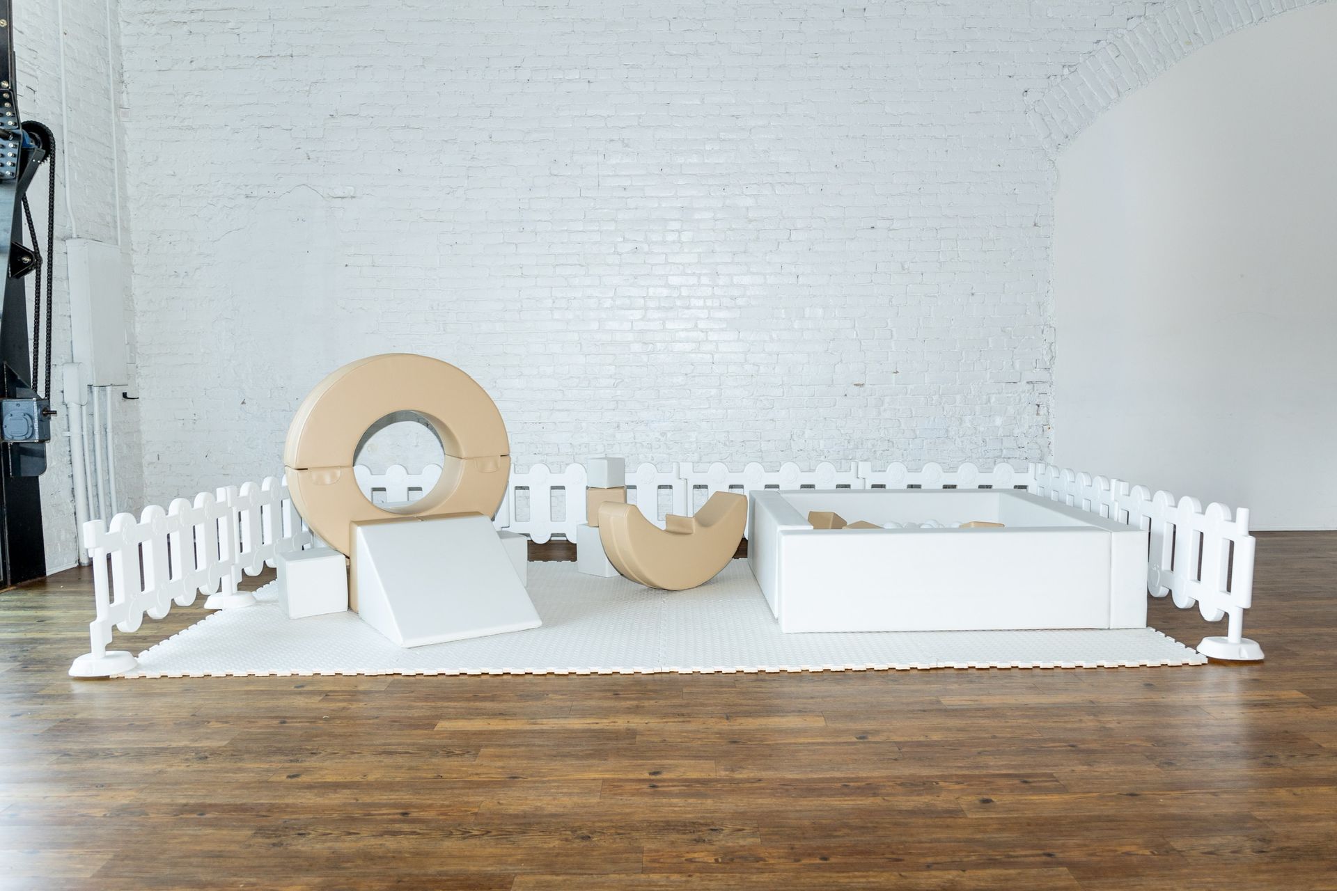 A room with a wooden floor and a white fence.