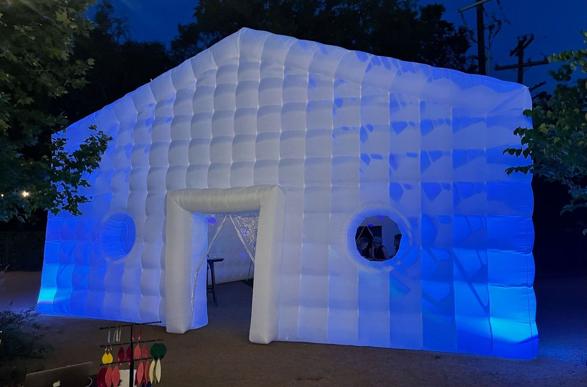 A large inflatable building is lit up with blue lights at night.