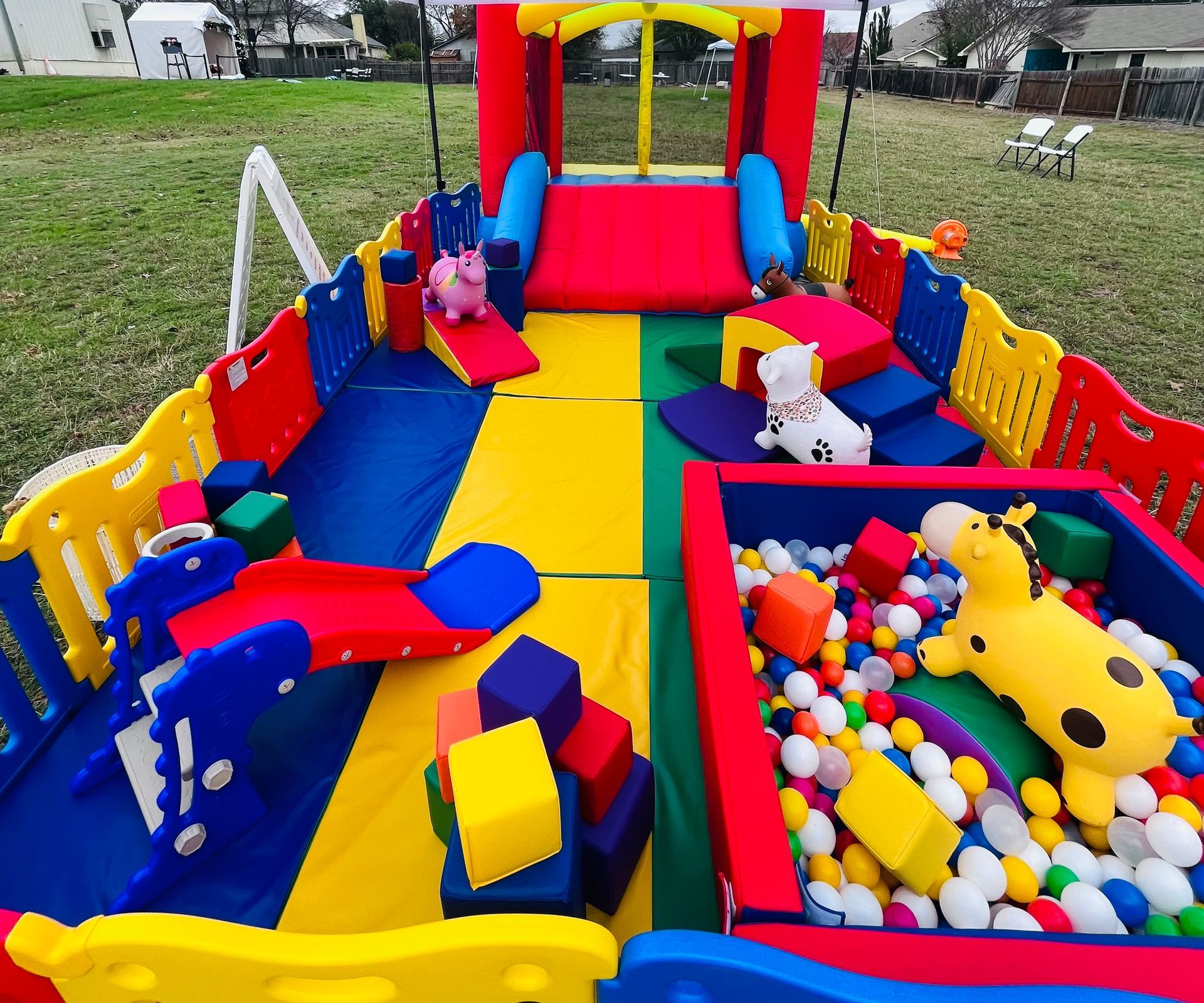 A colorful playground with a bouncy house and a ball pit.