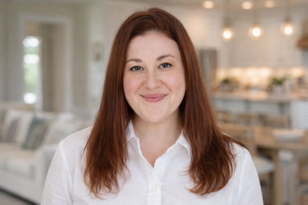 Jessica Cunningham with Aging in Place North Carolina -
A person with shoulder-length reddish-brown hair, wearing a white collared shirt, smiles warmly in a bright home interior.