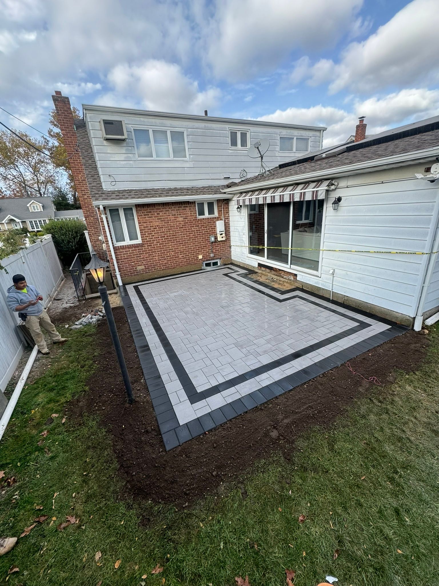 A patio is being built in the backyard of a house.