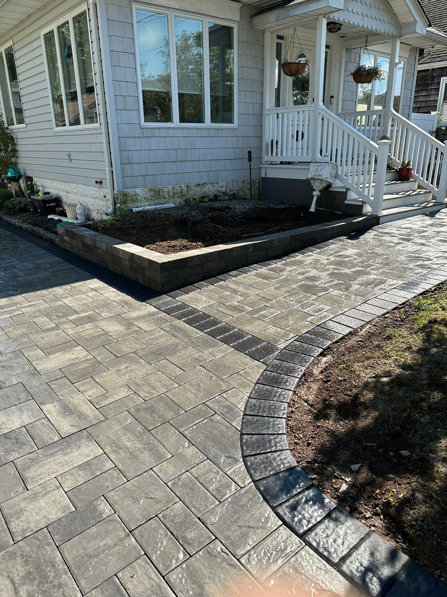 A white house with a brick walkway leading to the front door.