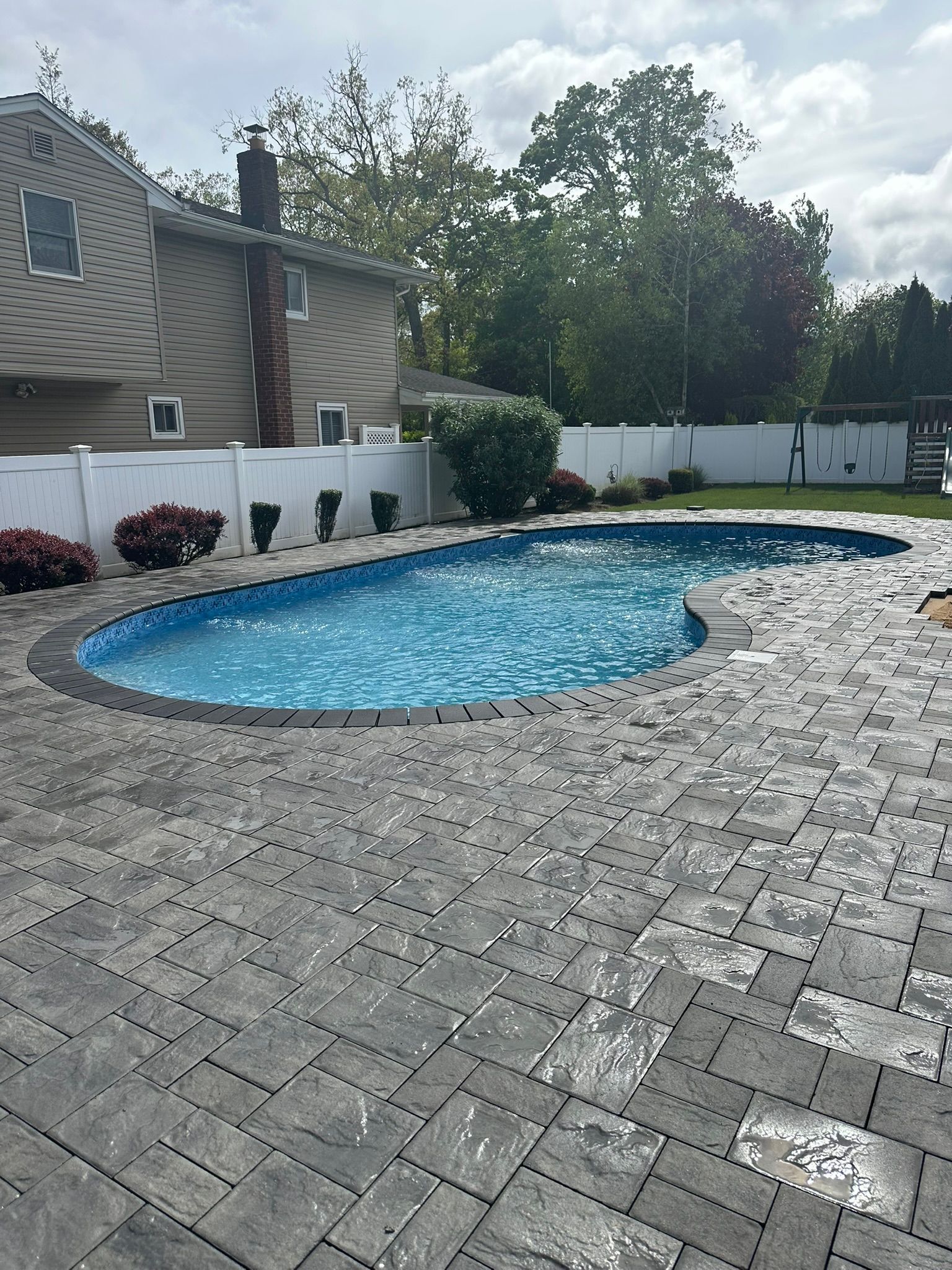 A large swimming pool in the backyard of a house