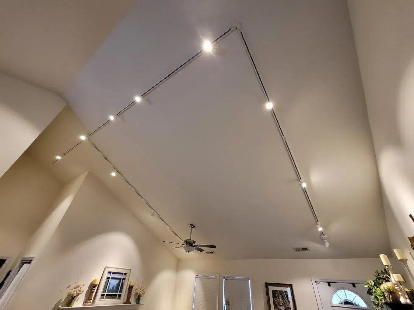 String lights attached to the ceiling of a room, surrounding the space.