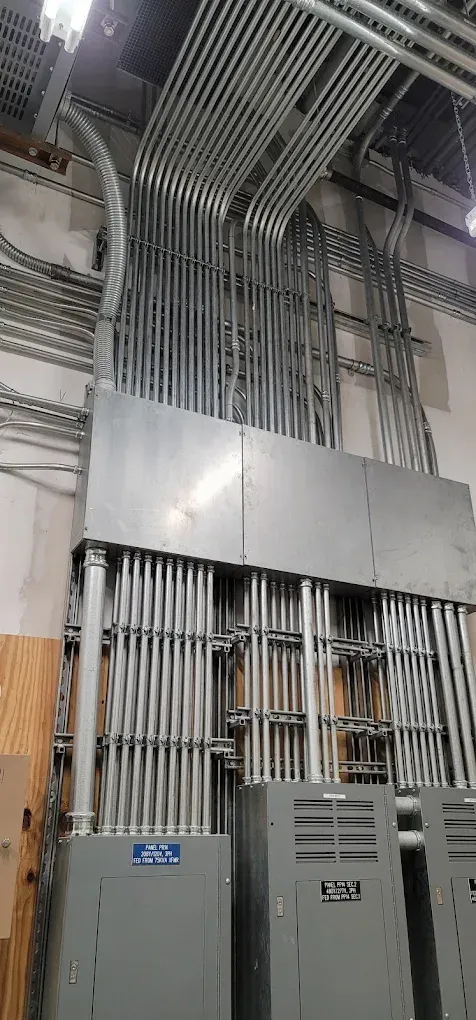 Electrical conduit runs along a wall. Metal boxes below.