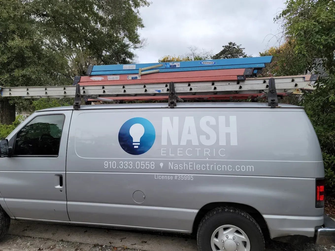 Silver van with ladder rack, branded 