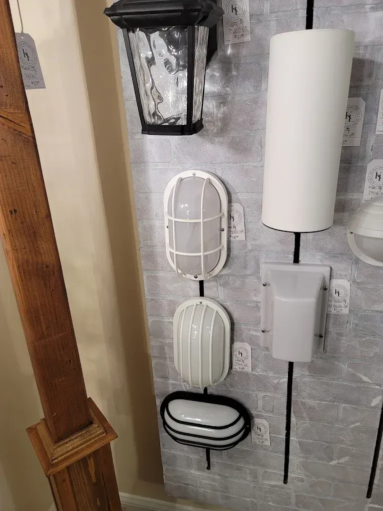 Various outdoor wall-mounted lights on display against a gray brick-patterned wall.