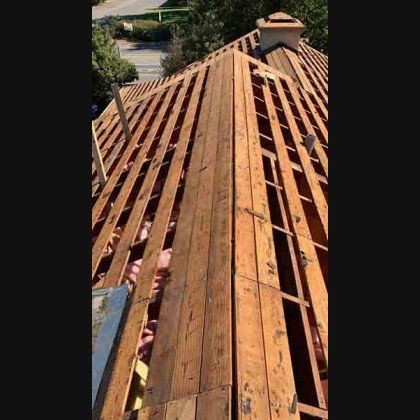 Wooden roof under construction; exposed beams and partial planking.