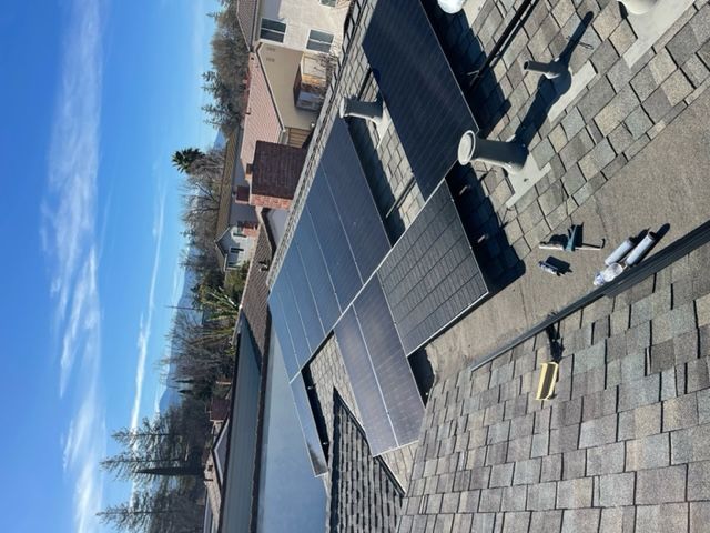 Solar panels installed on a residential roof under a blue sky.