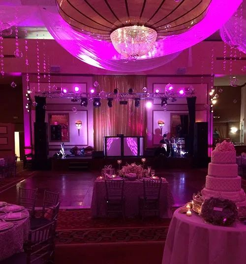 A large room with tables and chairs and a cake on a table.