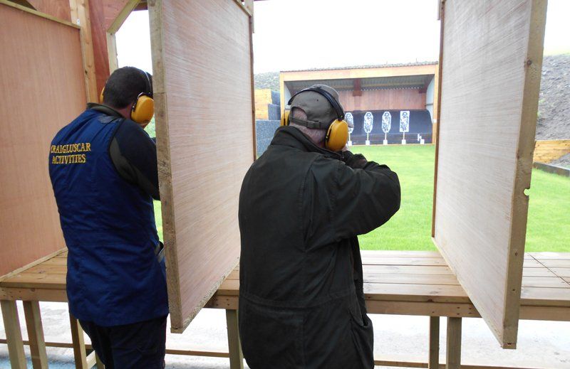 Two men wearing ear muffs and a vest that says ' national action ' on it