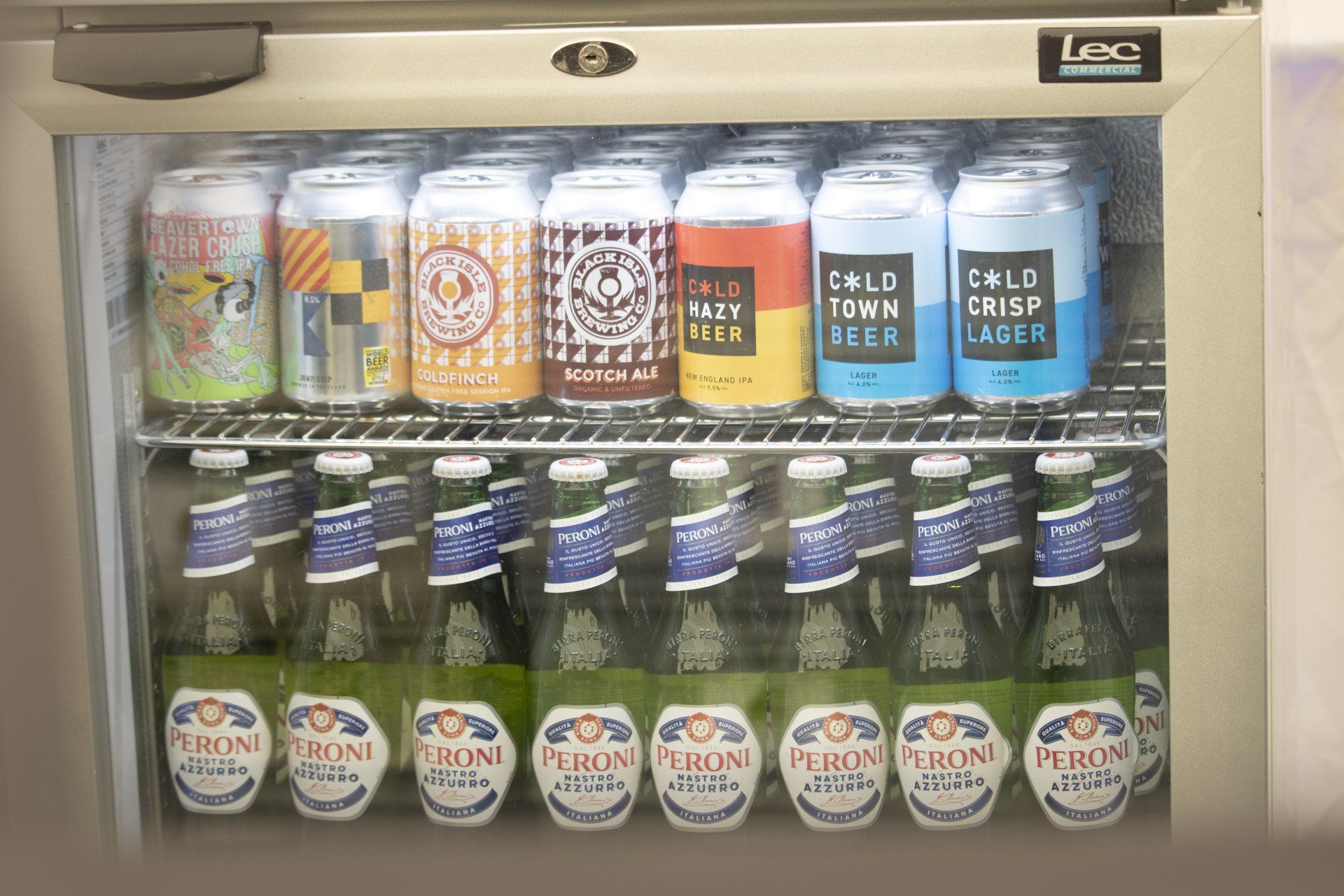 A refrigerator filled with cans and bottles of beer including a bottle of kirin beer
