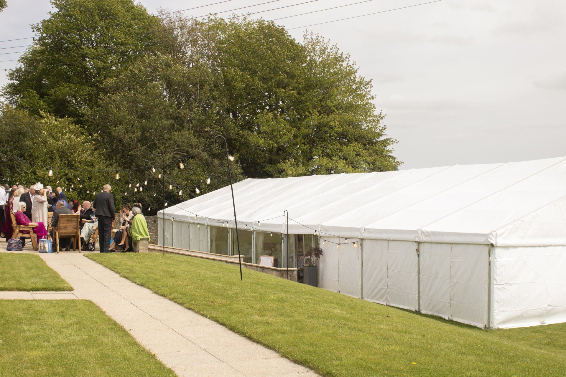 A group of people are sitting under a white tent