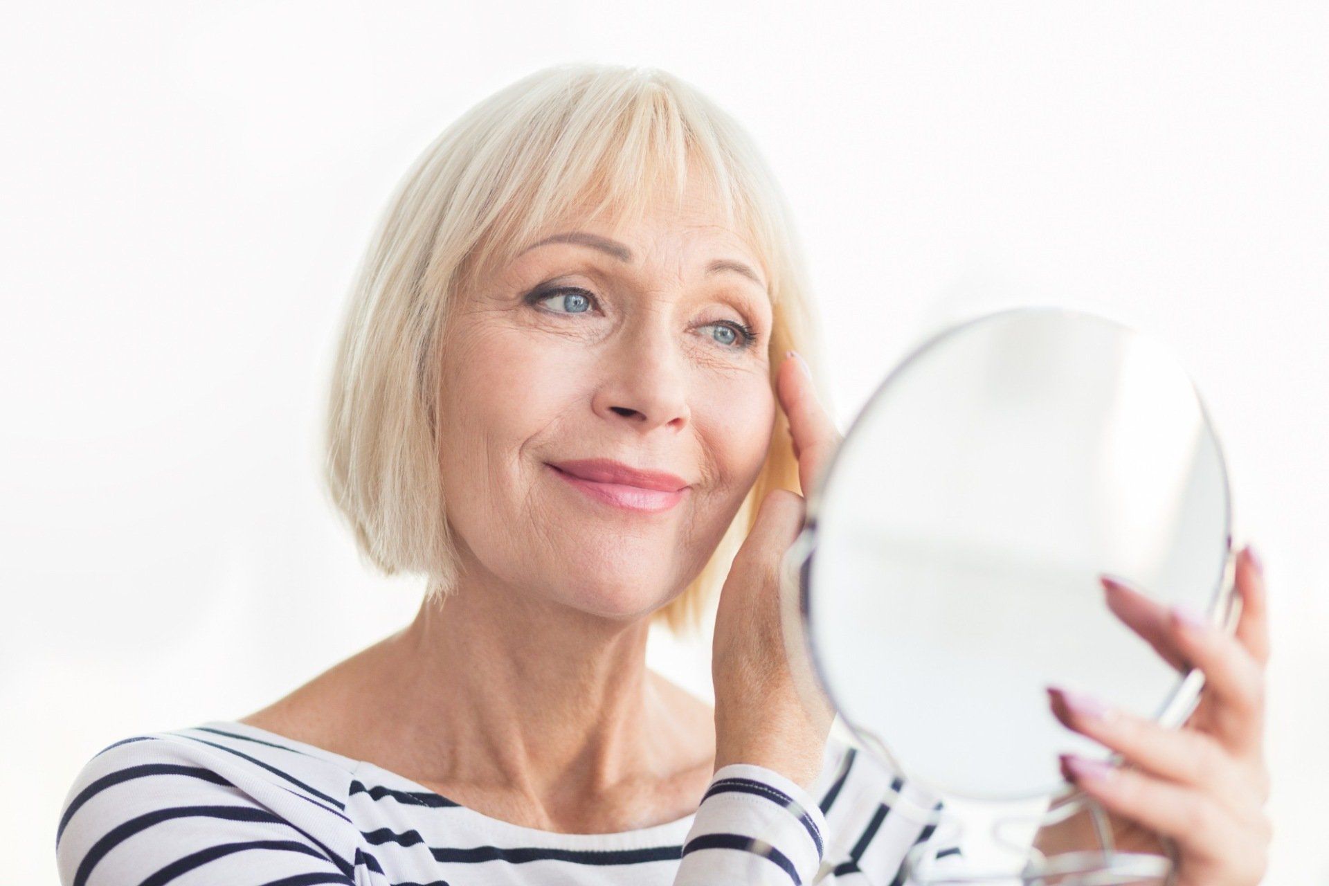 happy woman smiling at mirror